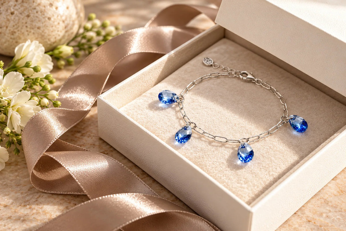 Ella blue crystal charm bracelet by Carabella by Cheryl, presented in an elegant ivory jewellery gift box with champagne satin ribbon.