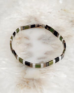 Ainsley Miyuki Tila bracelet featuring green black silver and gold rectangular beads shown in a clean minimalist product view