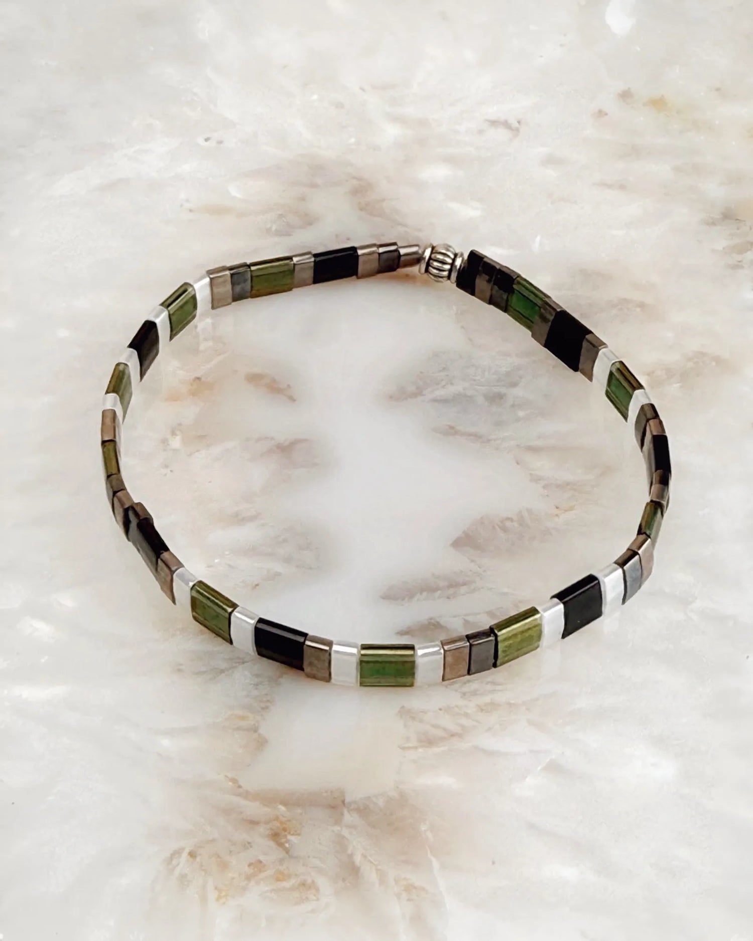 Ainsley Miyuki Tila bracelet featuring green black silver and gold rectangular beads shown in a clean minimalist product view