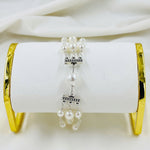 Elegant triple pearl bracelet with sterling silver accents displayed on jewelry stand