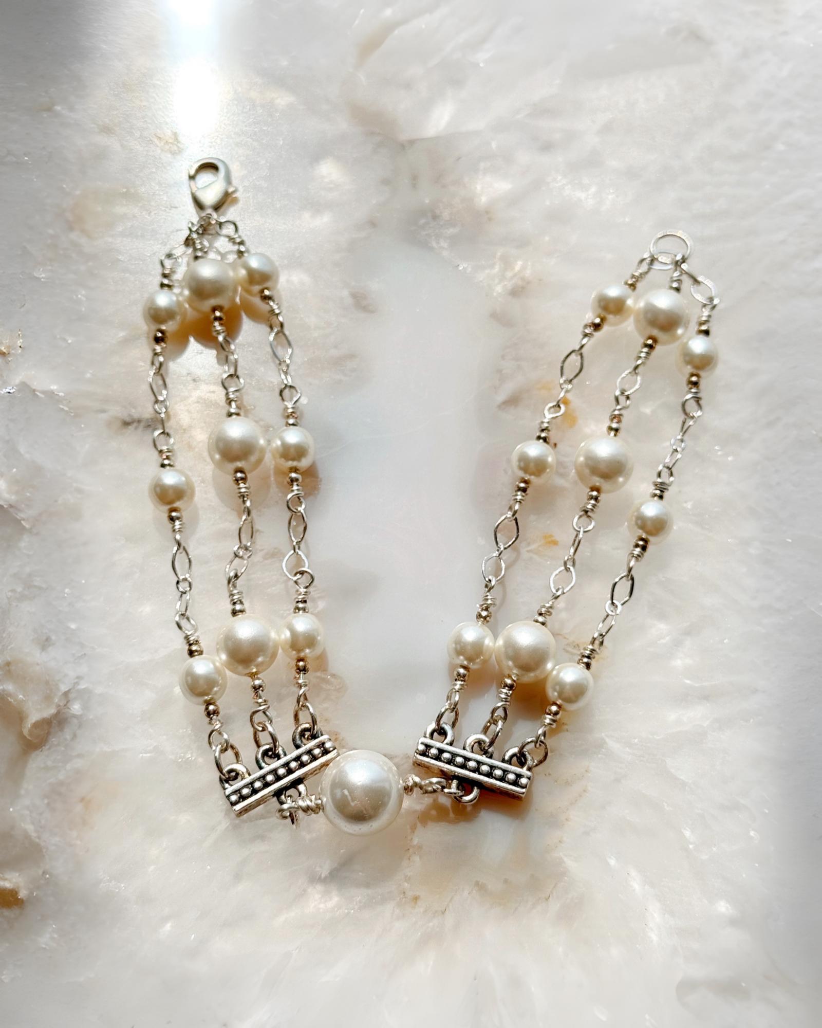 Triple strand pearl bracelet featuring Austrian crystal pearls and sterling silver detailing