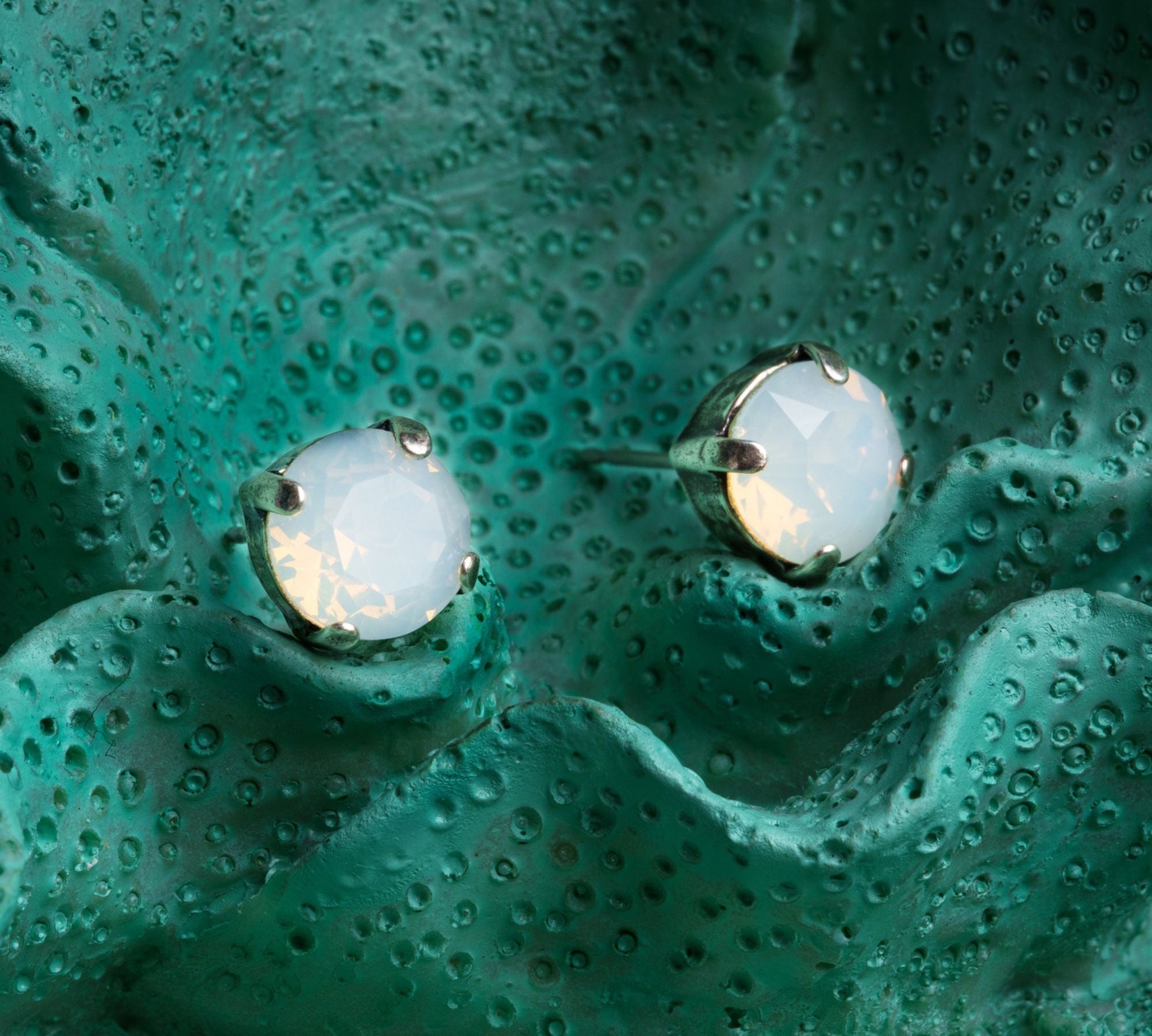 Close up of Capri Austrian crystal stud earrings showcasing luminous faceted stones and understated luxury design