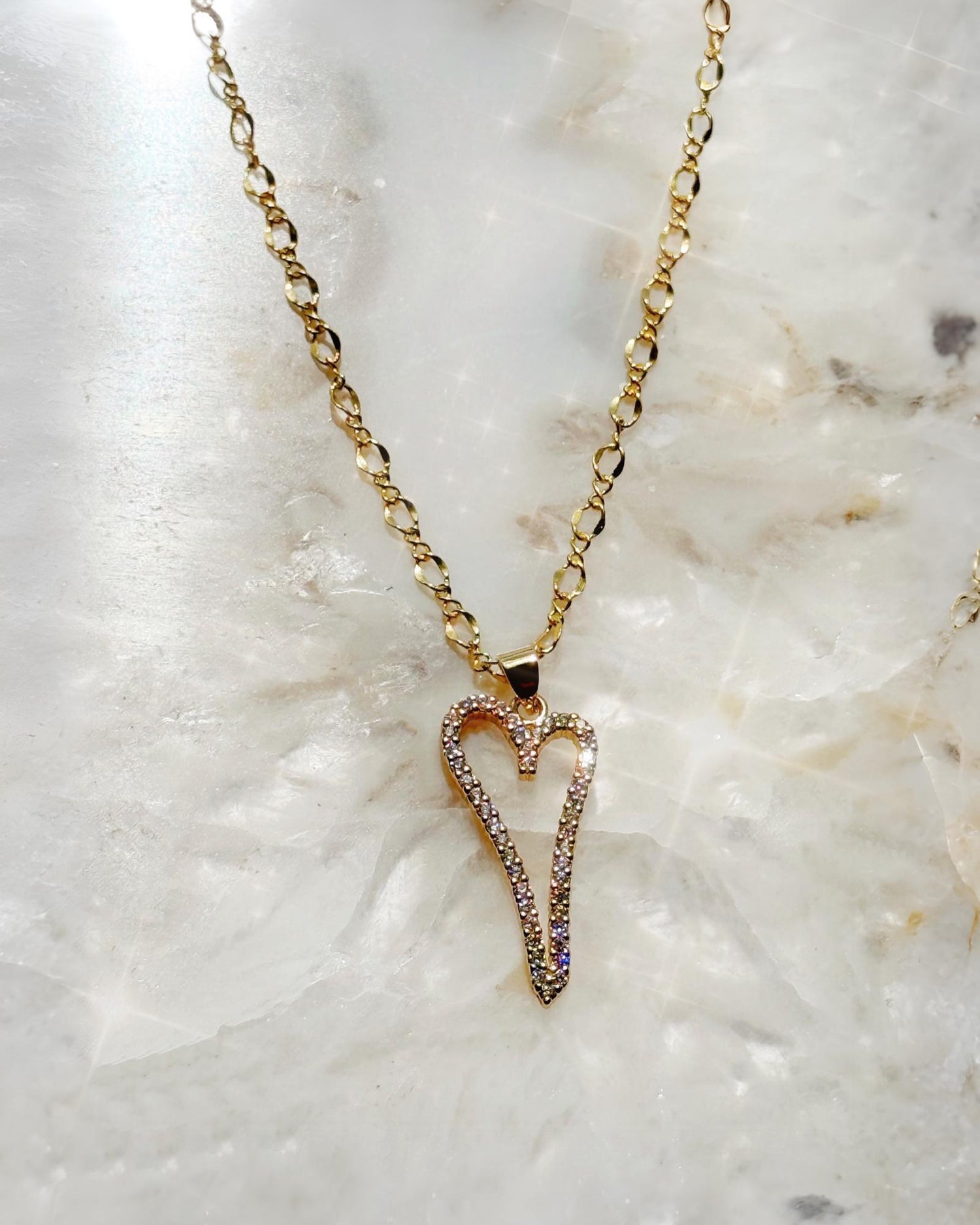 Cara Gold Heart A Necklace with pave heart pendant photographed on a crystal stone background