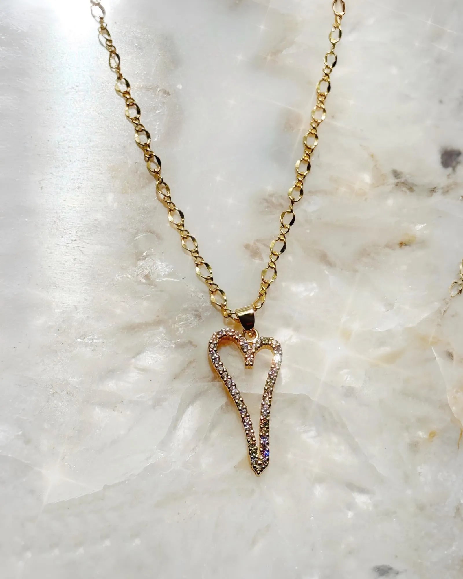 Cara Gold Heart A Necklace with pave heart pendant photographed on a crystal stone background