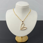 Angled view of Cara Gold Heart B Necklace featuring a pave heart pendant on gold chain