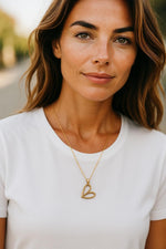Close up of Cara Gold Heart B Necklace featuring a pave heart pendant on a gold chain