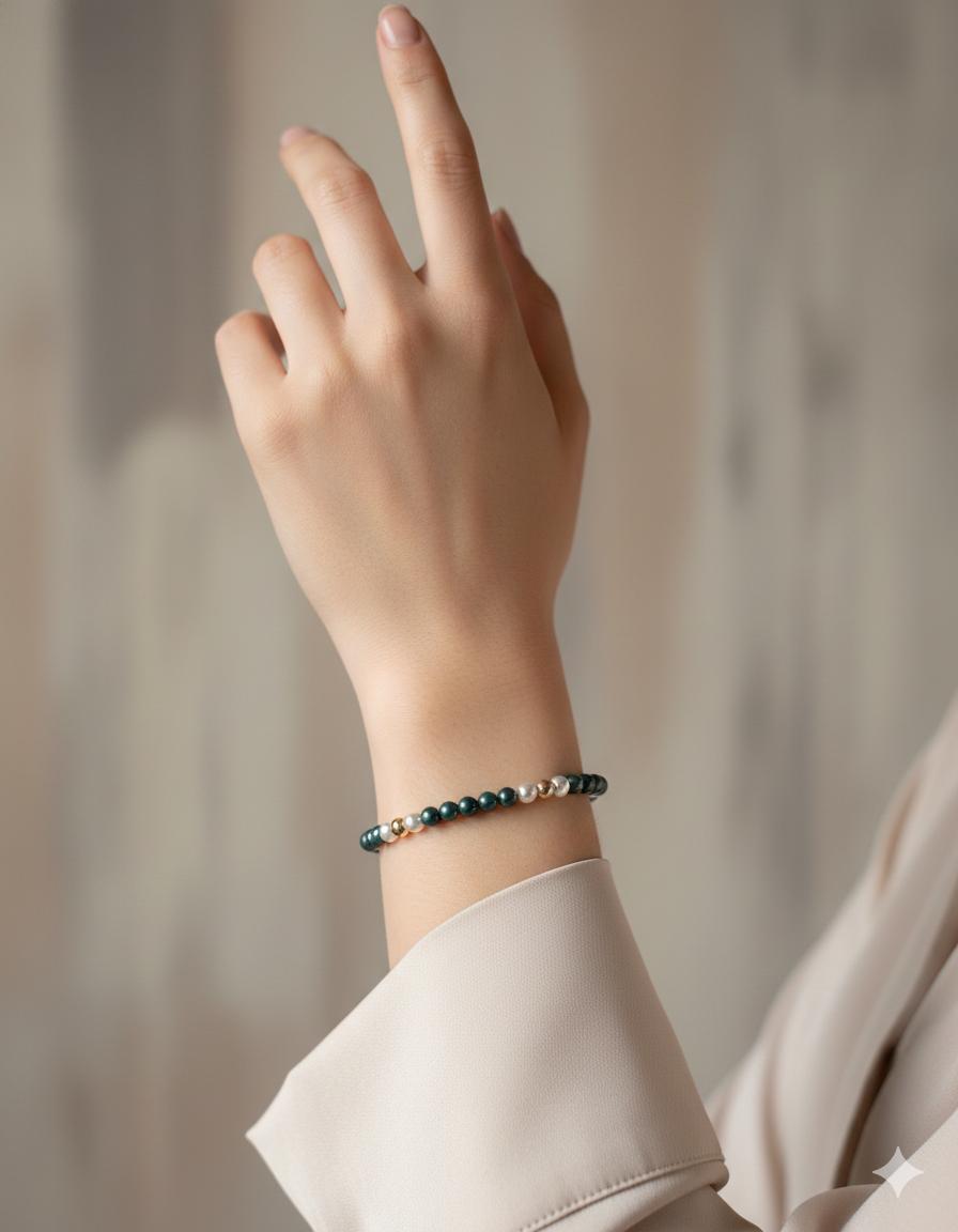 Kaia Pearl Stretch Bracelet worn on the wrist showcasing deep teal and moonlight pearl tones with refined gold accents