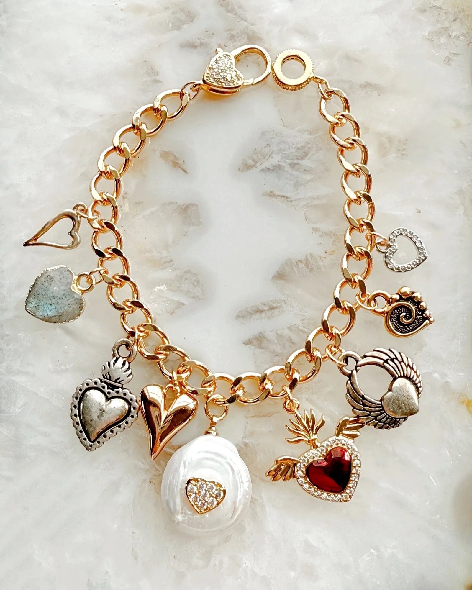 Esme charm bracelet featuring multi-metal heart charms and a sparkling micro-pavé heart clasp, handcrafted in Canada.