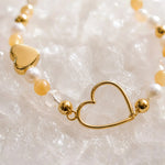 Close-up of the Harlow Gold Bracelet highlighting the handcrafted open gold heart, honey opal gemstones, Swarovski® Crystal Pearls and crystal accents.