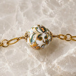Close-up detail of a rare Japanese Tensha bead showcasing intricate floral artwork and gold accents on the Imperial Blossom Necklace.