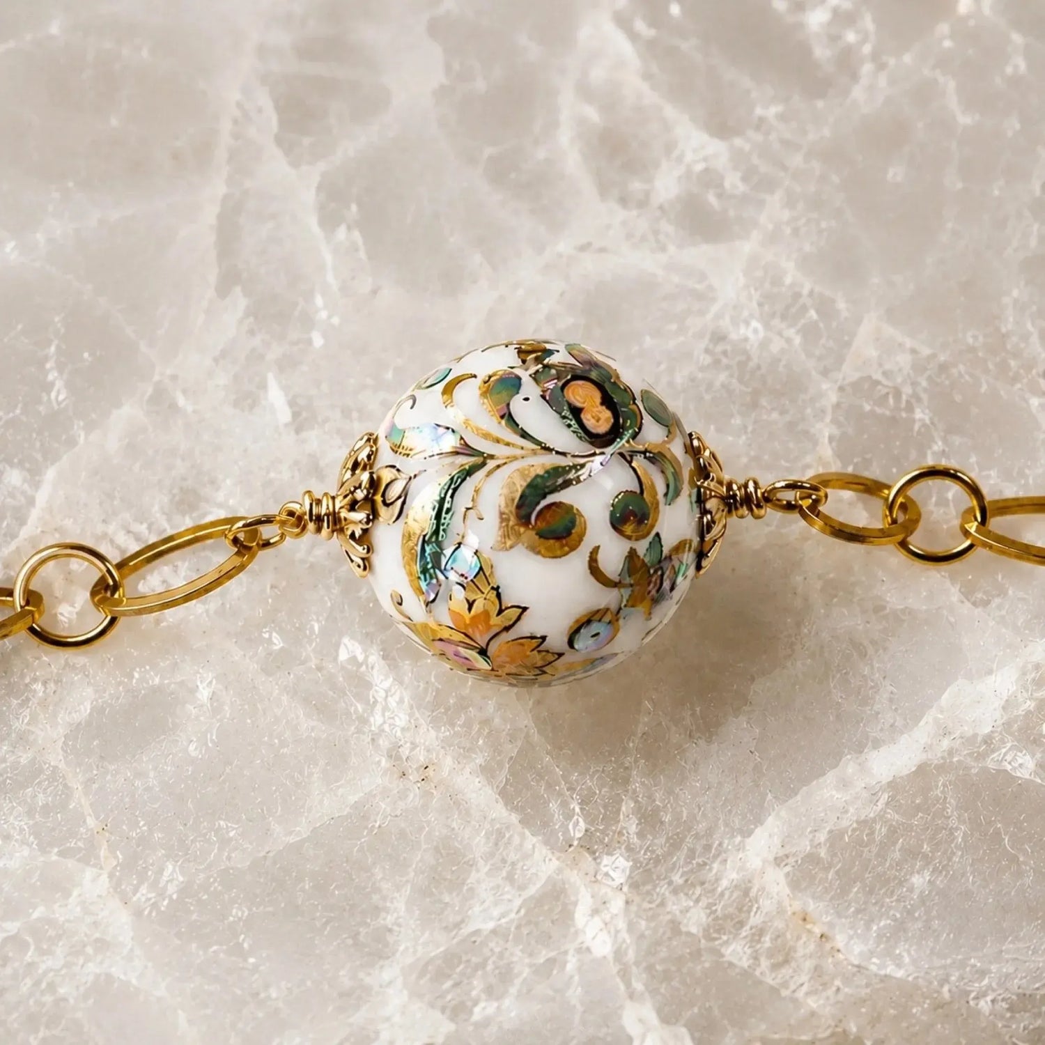 Close-up detail of a rare Japanese Tensha bead showcasing intricate floral artwork and gold accents on the Imperial Blossom Necklace.