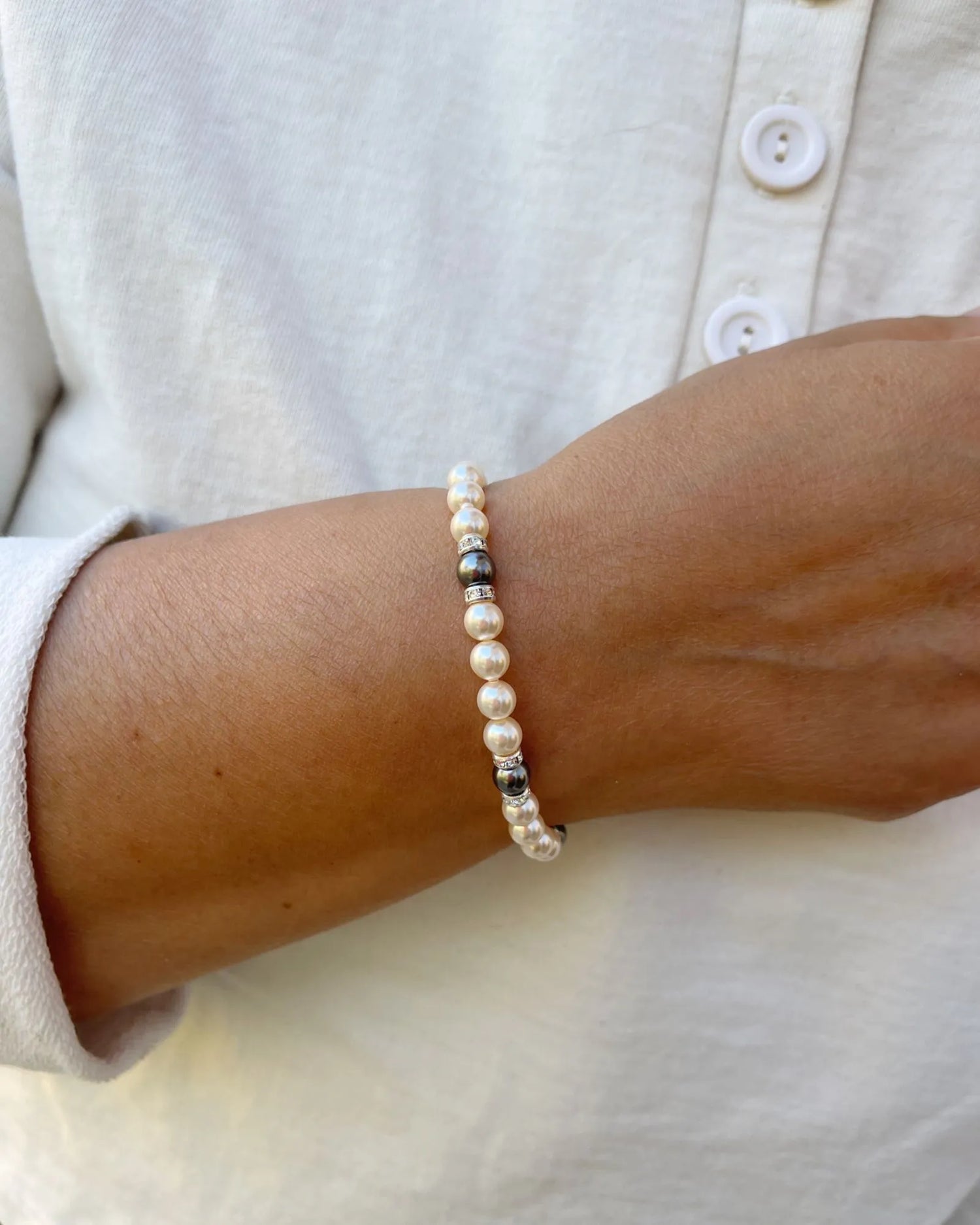 Juanita Pearl Stretch Bracelet worn on the wrist, featuring cream and dark grey European crystal pearls in an elegant stretch silhouette