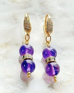 Kalei Amethyst and Gold Earrings by Carabella by Cheryl, handcrafted in Canada with rich purple amethyst gemstones, Austrian crystal accents, and 18k gold cubic zirconia-encrusted settings—luxury gemstone earrings for women.