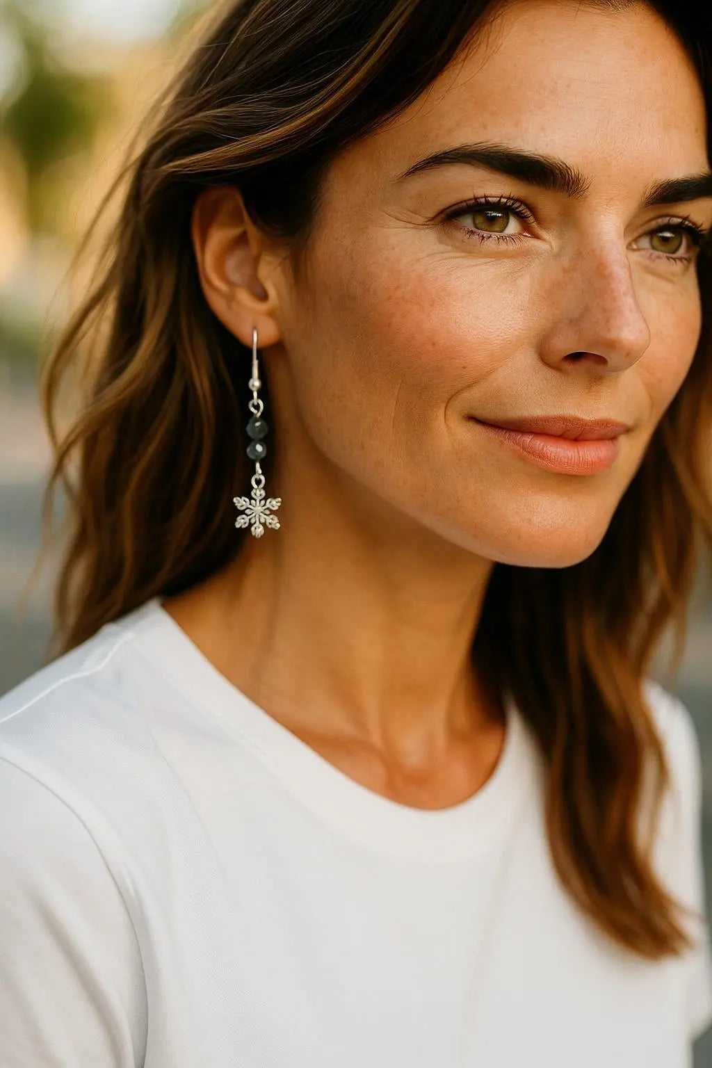 Model wearing the Sapphire Snowflake Earrings, styled as an elegant everyday statement with sterling silver snowflake charms and soft blue crystal sparkle for a refined, seasonal look.