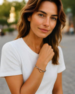 Model wearing silver paperclip bracelet with gold heart clasp modern stacking jewelry