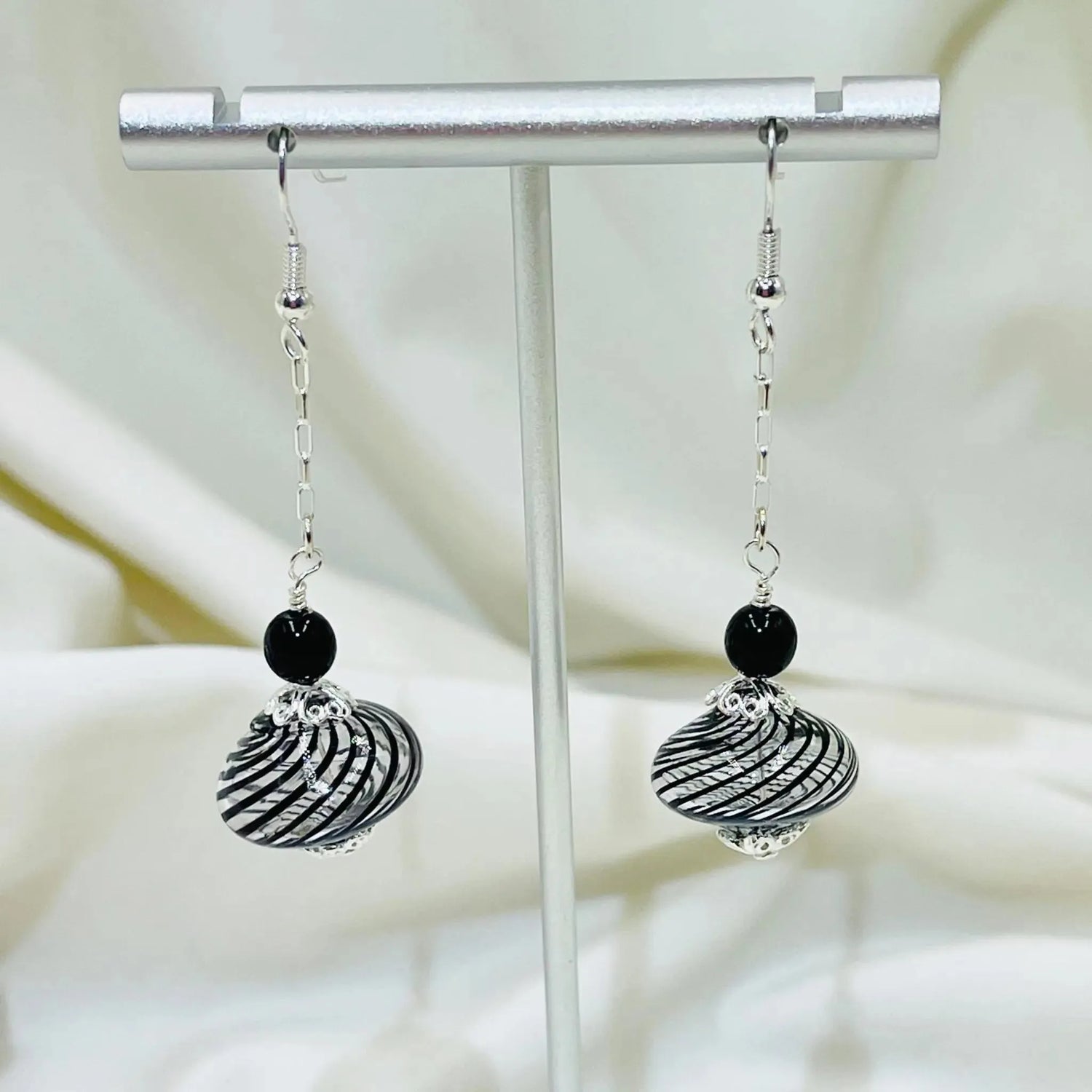 Venezia Murano Glass Earrings in sterling silver displayed on a jewelry stand, highlighting the Venetian inspired Murano glass bead design.