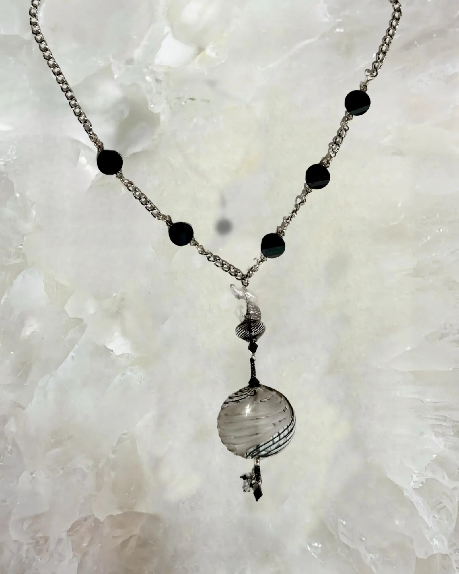 Close up detail of the Venezia Murano Glass Statement Necklace showcasing the handcrafted Murano glass pendant with black and silver patterning and crystal accents.