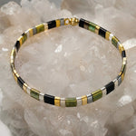 Ainsley Miyuki Tila Bracelet displayed on a luminous white quartz crystal cluster, highlighting the clean geometric design and premium Japanese Miyuki glass beads.