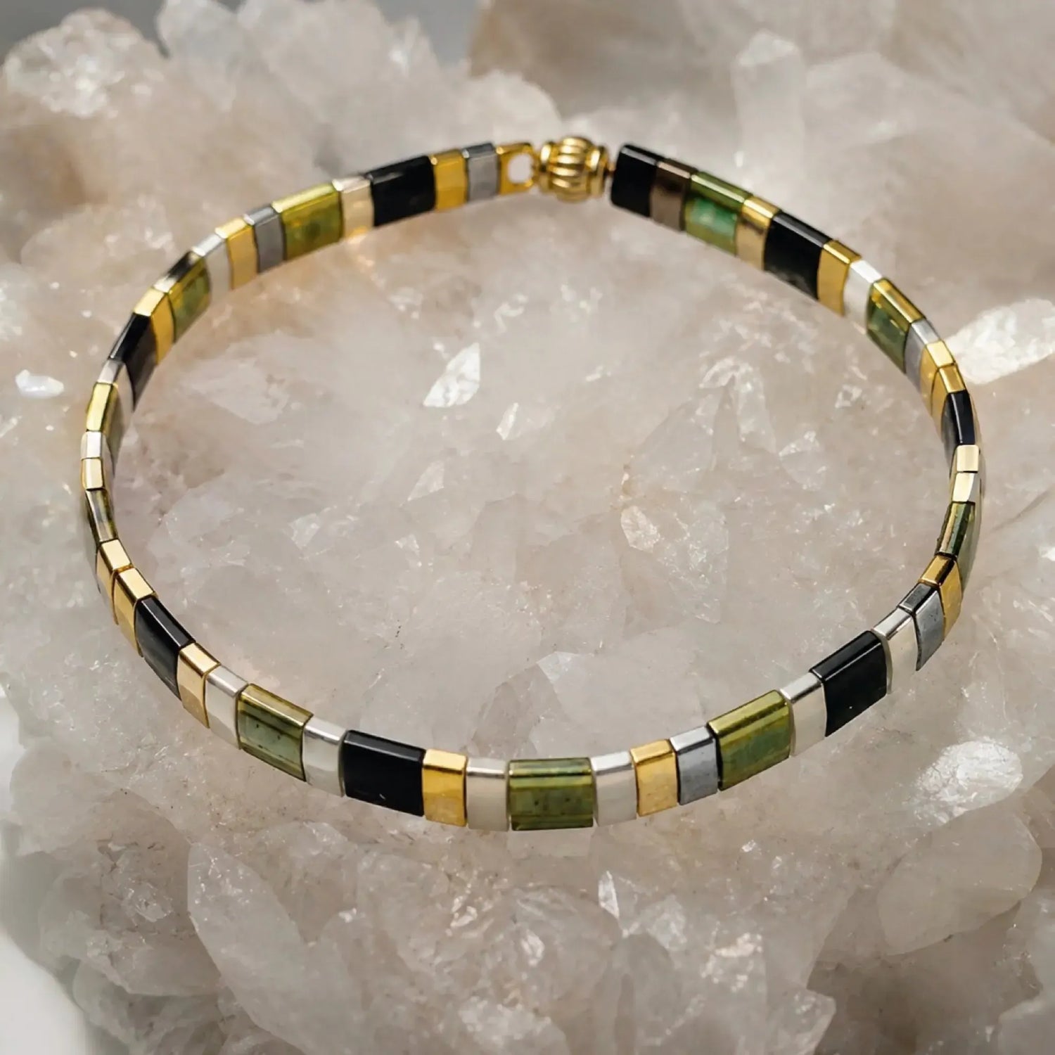 Ainsley Miyuki Tila Bracelet displayed on a luminous white quartz crystal cluster, highlighting the clean geometric design and premium Japanese Miyuki glass beads.