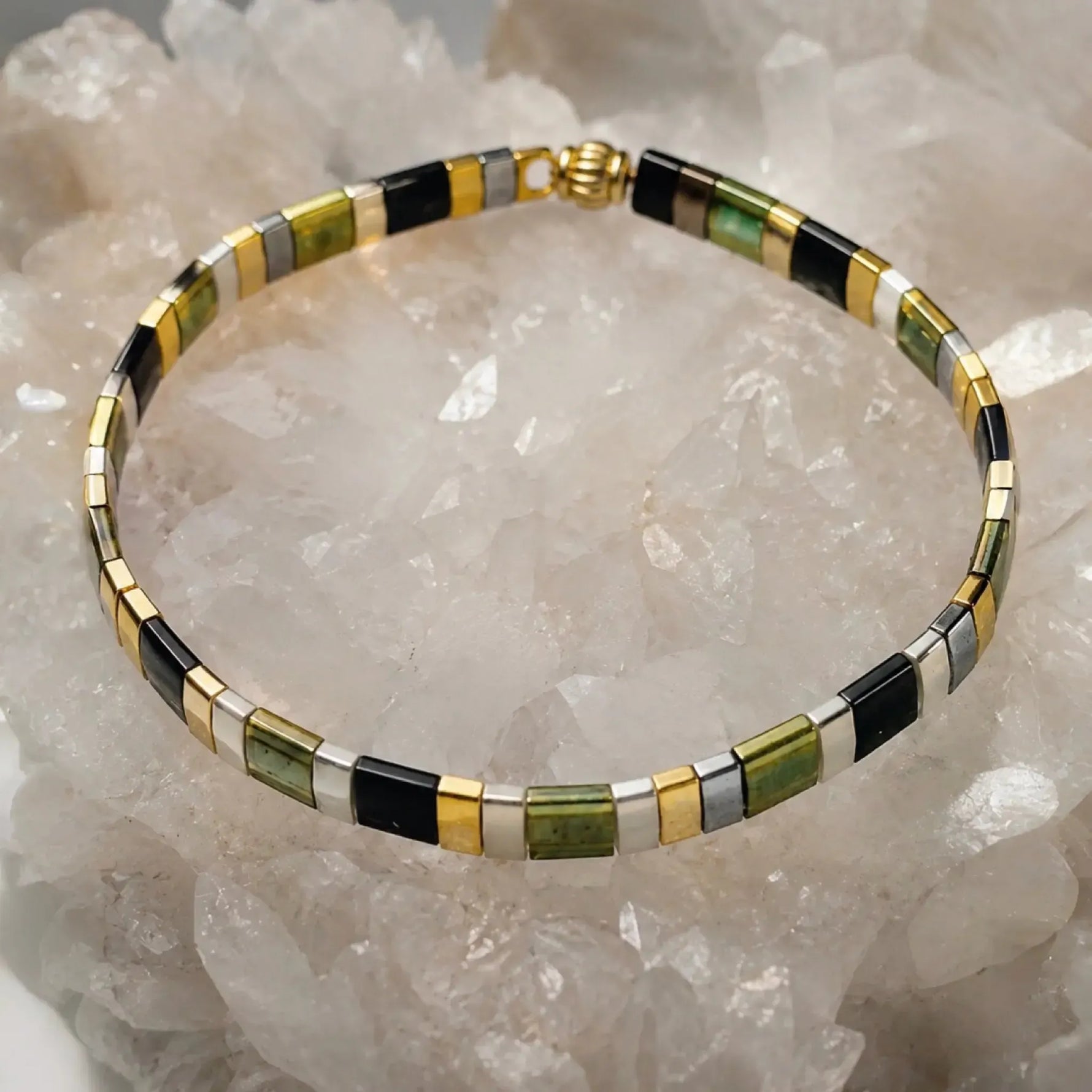 Ainsley Miyuki Tila Bracelet displayed on a luminous white quartz crystal cluster, highlighting the clean geometric design and premium Japanese Miyuki glass beads.