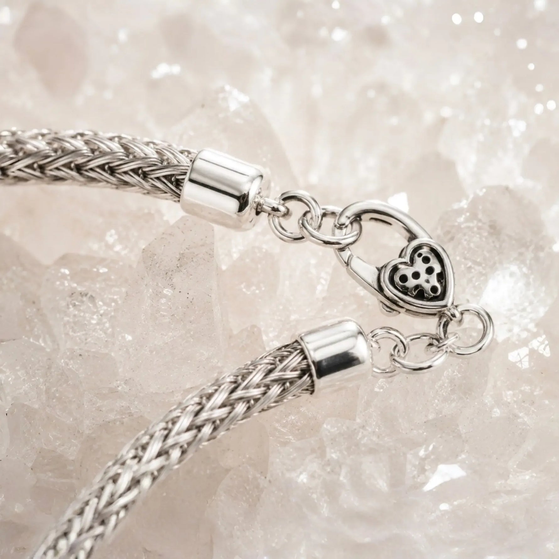 Close-up of the Ava bracelet featuring the handwoven .999 fine silver weave, polished sterling silver end caps, jump rings, and decorative heart lobster clasp.