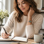 Woman wearing the Ava handwoven .999 fine silver bracelet with natural green agate druzy while writing at a desk in soft natural light.