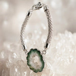 Ava handwoven .999 fine silver bracelet standing in a graceful curve on white quartz with the natural green agate druzy showcased as the sculptural focal point.