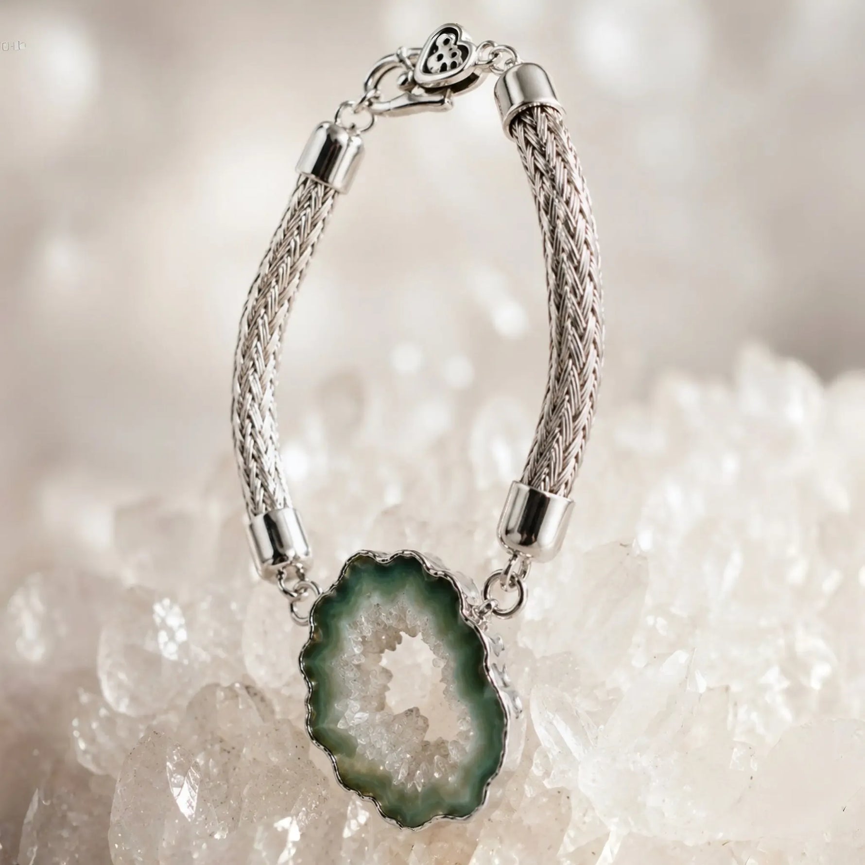 Ava handwoven .999 fine silver bracelet standing in a graceful curve on white quartz with the natural green agate druzy showcased as the sculptural focal point.