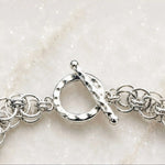 Macro view of the Avalon bracelet’s hammered sterling silver toggle clasp and adjoining handwoven Celtic helm links.