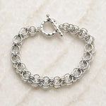 Avalon sterling silver bracelet with an intricate handwoven Celtic helm chainmaille design and hammered toggle clasp on white quartz.