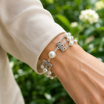Close-up of the Calla triple strand Swarovski® Crystal Pearl bracelet worn with an ivory silk blouse, showing natural fit and elegant proportions.