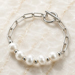 Angled view of the Callie freshwater pearl bracelet featuring 9–10 mm freshwater pearls, polished silver paperclip chain and toggle clasp.