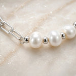 Macro detail of the Callie bracelet highlighting luminous 9–10 mm freshwater pearls, polished silver spacer beads and handcrafted construction.