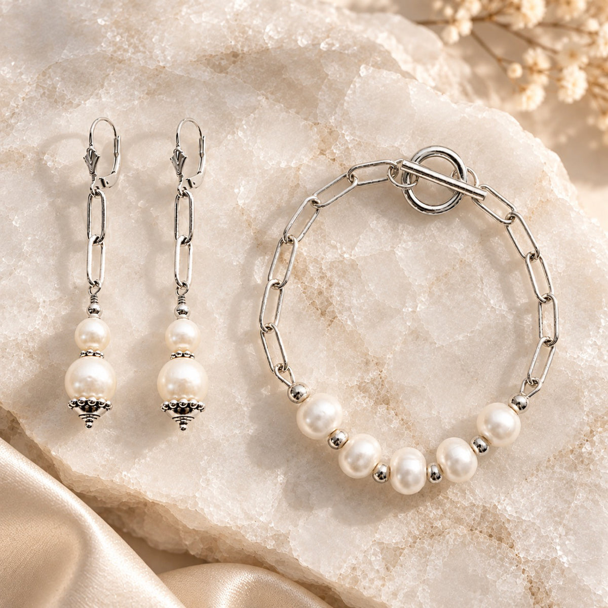 Callie freshwater pearl earrings with matching five-pearl bracelet styled on white quartz