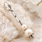Close-up of a Callie freshwater pearl earring showing paperclip chain, pearl detailing and fleur-de-lis leverback