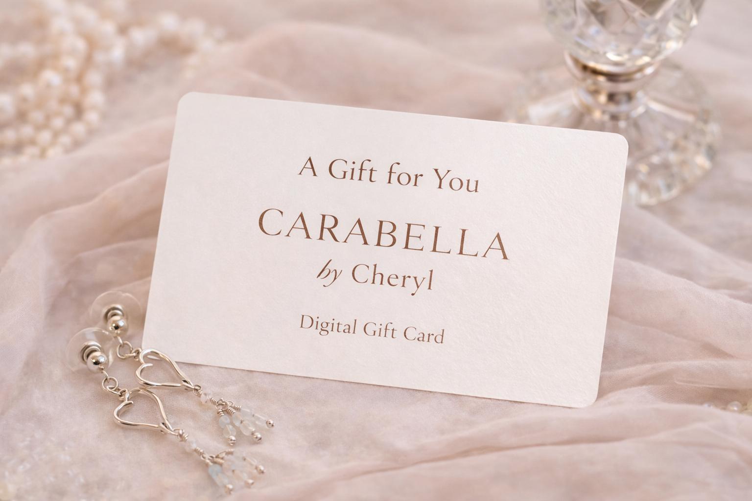 Carabella by Cheryl digital gift card styled with sterling silver heart earrings, soft blush fabric, pearls, and crystal accents in an elegant luxury setting.