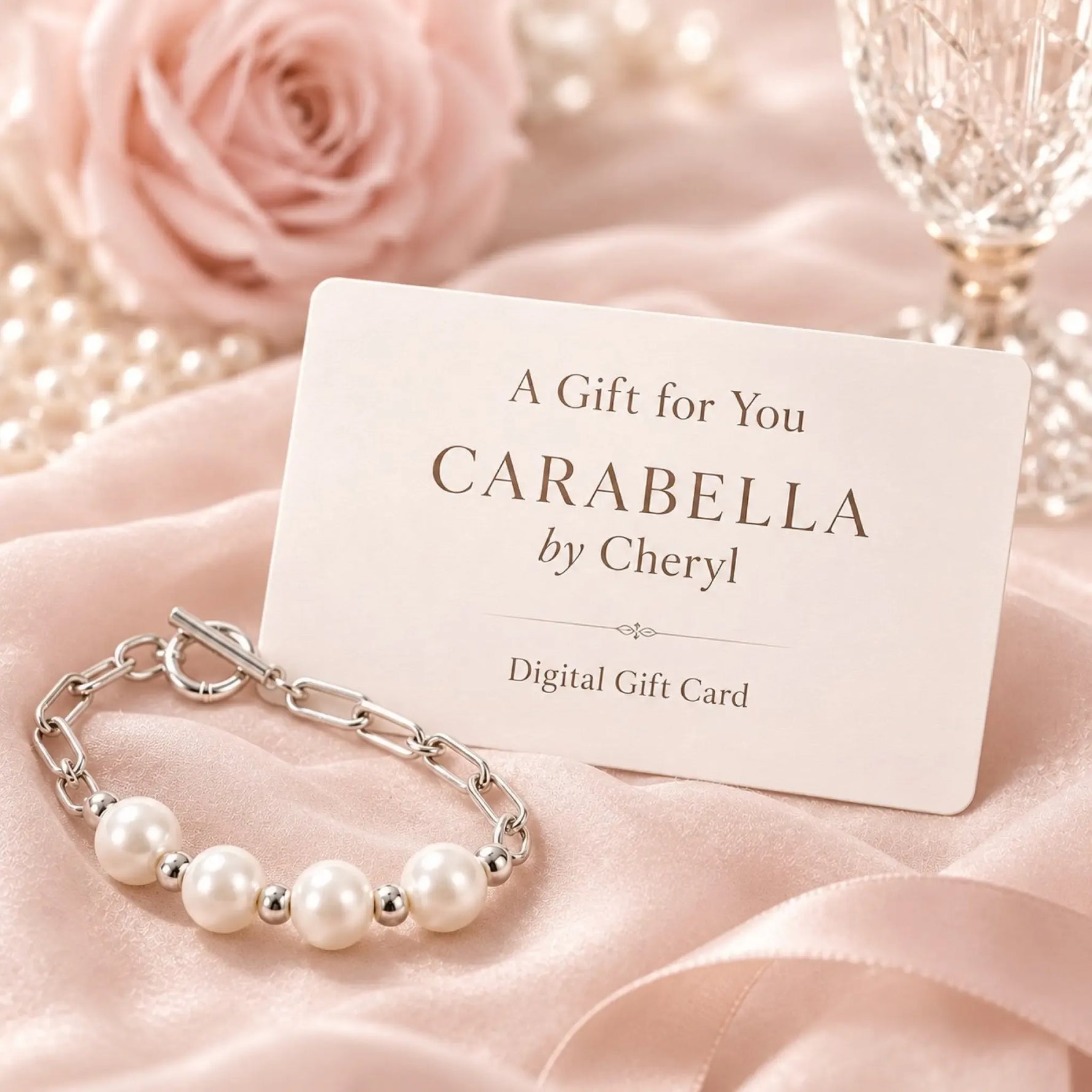 Carabella by Cheryl digital gift card displayed with the Callie freshwater pearl bracelet on blush silk, styled with a soft pink rose and crystal glass in an elegant luxury gift setting.