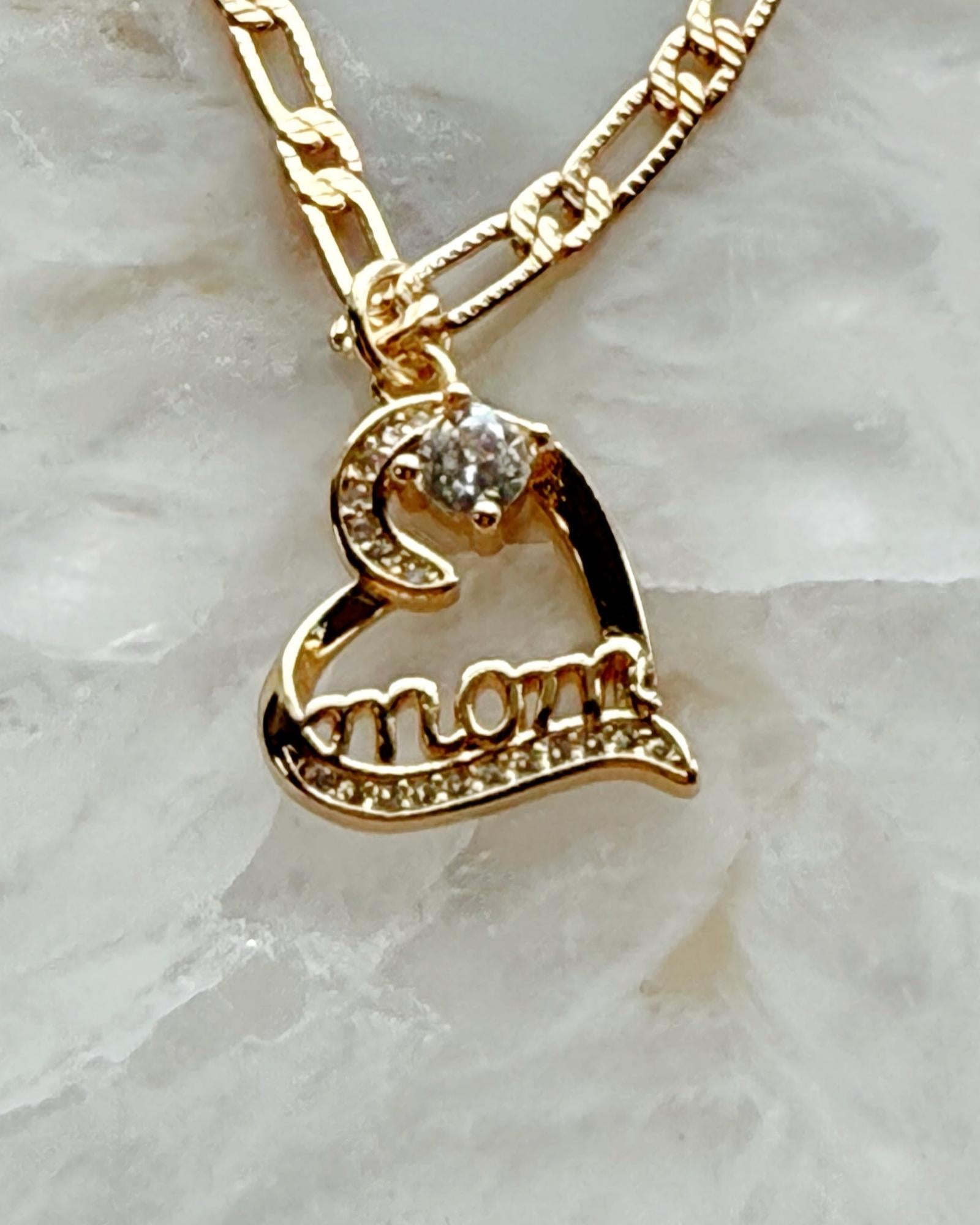 Close-up of the Eternal Love heart pendant engraved with “mom,” featuring cubic zirconia sparkle and gold-plated warmth in a refined Carabella by Cheryl luxury style.