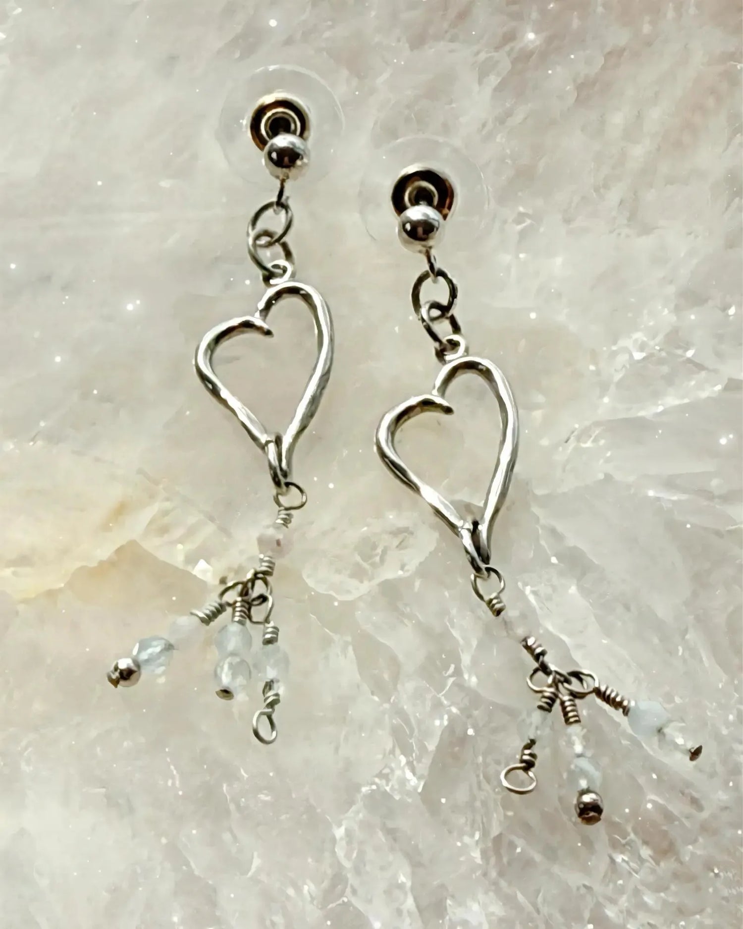 Morganite gemstone heart drop earrings in sterling silver, styled on a luminous crystal surface for an elegant and refined Carabella presentation.