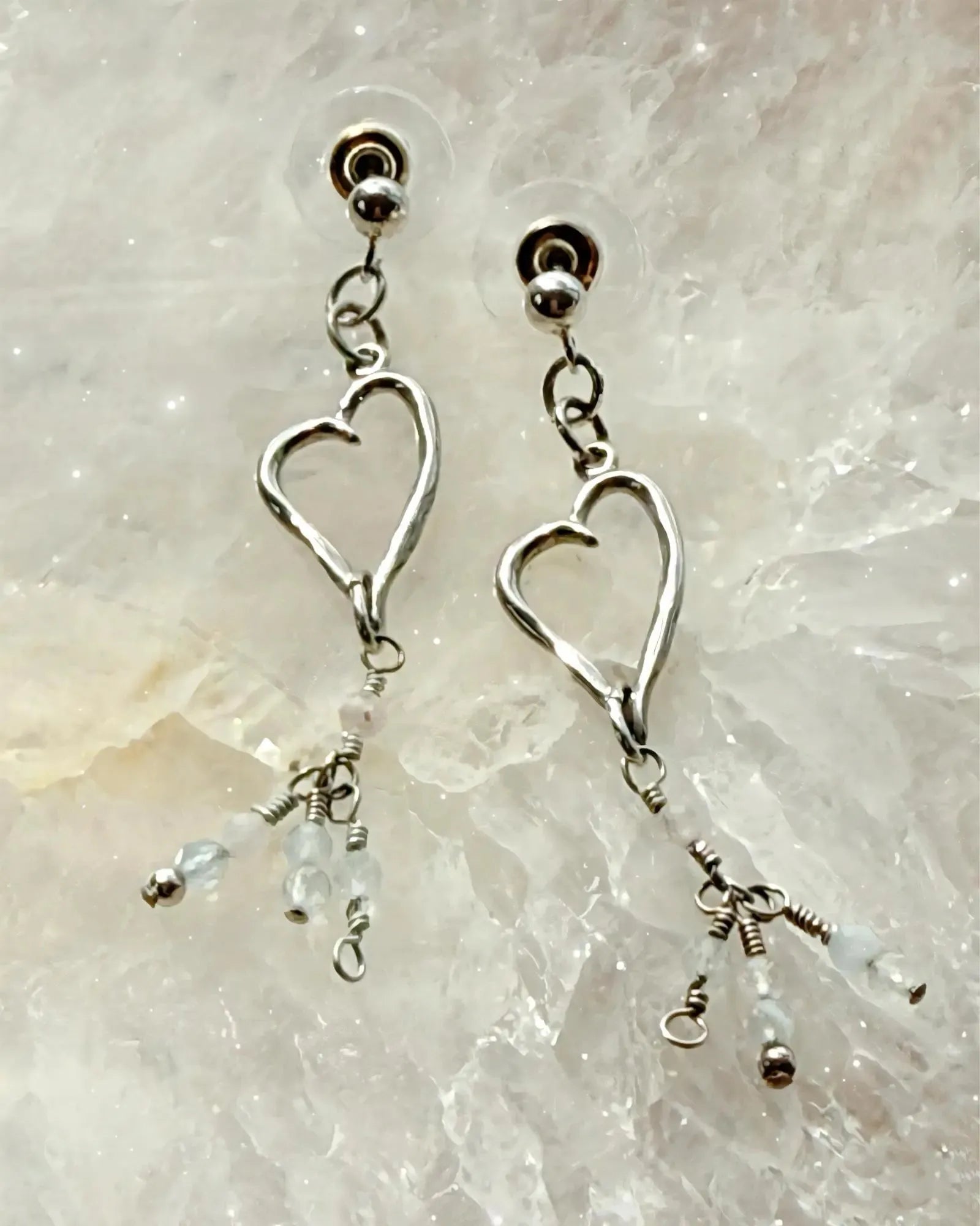 Morganite gemstone heart drop earrings in sterling silver, styled on a luminous crystal surface for an elegant and refined Carabella presentation.