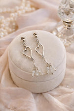 Sterling silver heart earrings with Morganite gemstones styled in a refined luxury still life, evoking timeless sophistication and polished femininity.