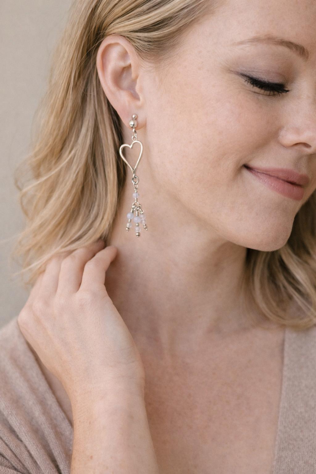 Model wearing Morganite gemstone heart earrings in sterling silver, captured in a soft editorial portrait that highlights quiet elegance and everyday luxury.