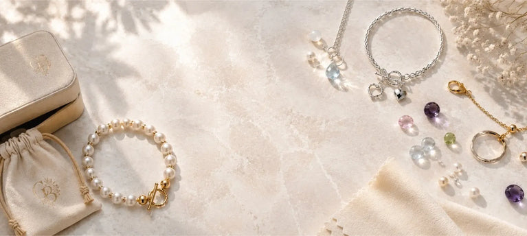 Carabella jewellery, pearls, gemstones and silver and gold details arranged with jewellery packaging and care accessories.