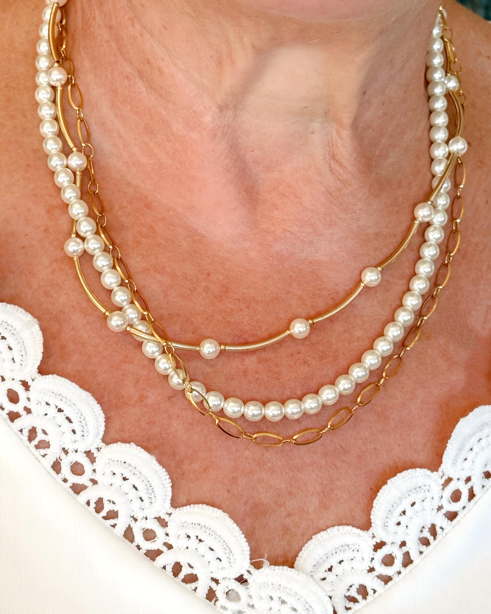 Model wearing Cassia pearl necklace styled with layered gold chain and crystal pearls, an elegant pearl necklace for everyday and special occasions