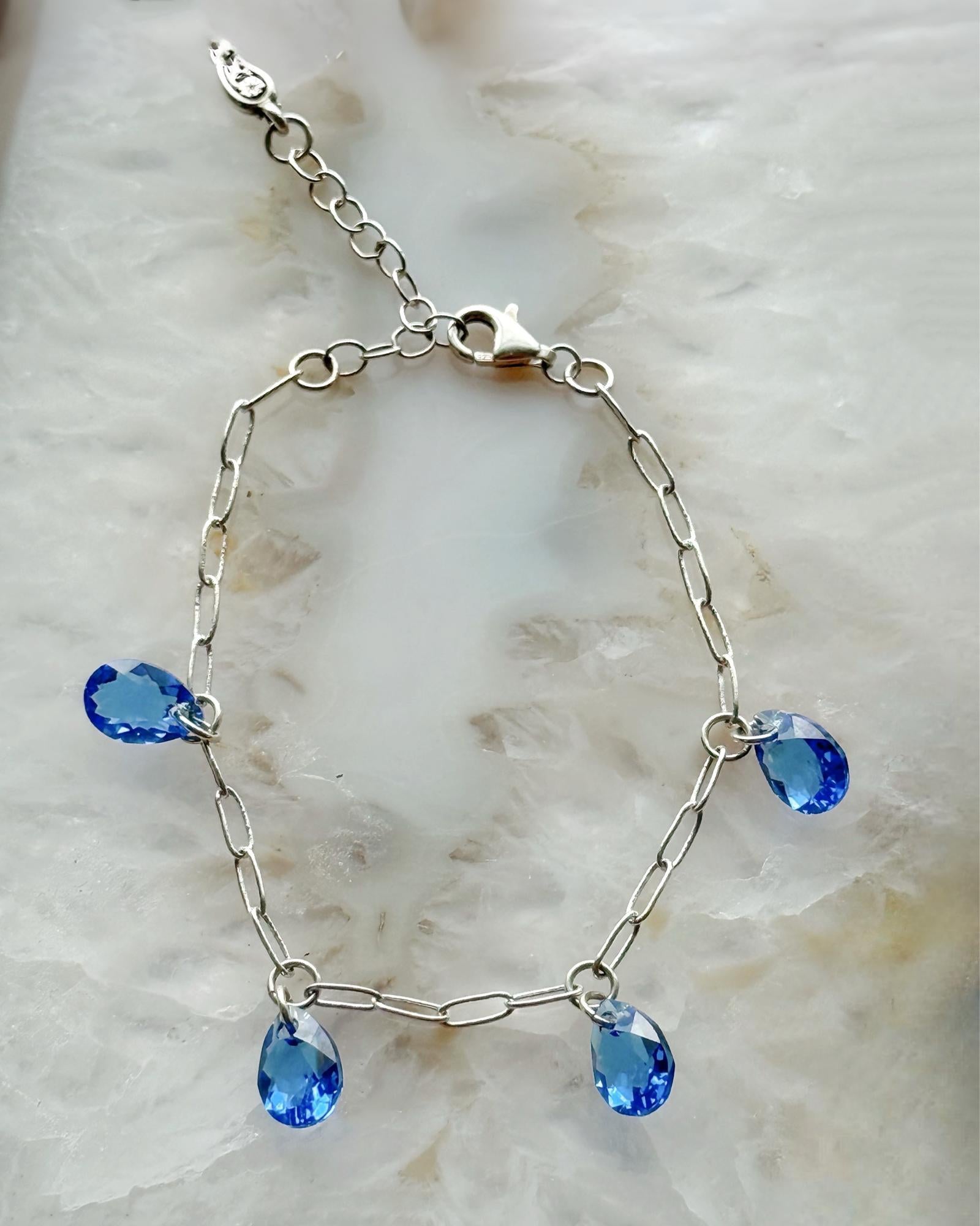 Detail view of the Ella Sapphire Crystal Drop Bracelet showcasing pear shaped sapphire crystals and adjustable sterling silver plated chain by Carabella by Cheryl