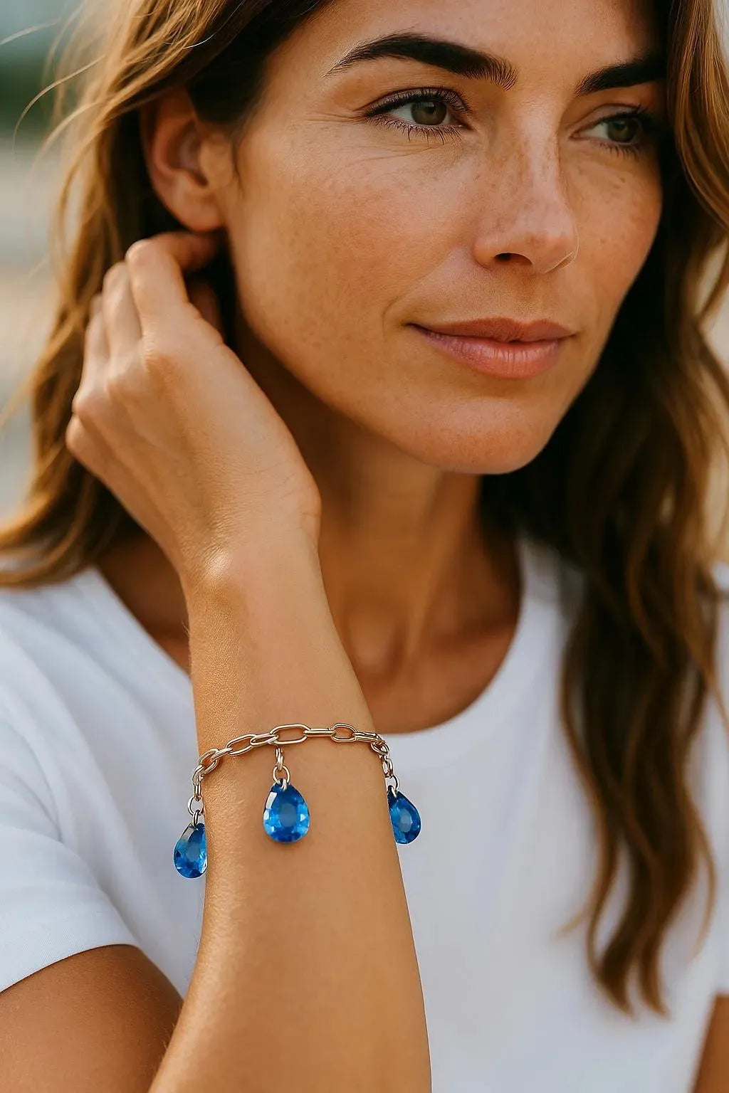 Ella Sapphire Crystal Drop Bracelet worn on model, featuring pear shaped sapphire blue European crystals on a sterling silver plated paperclip chain by Carabella by Cheryl