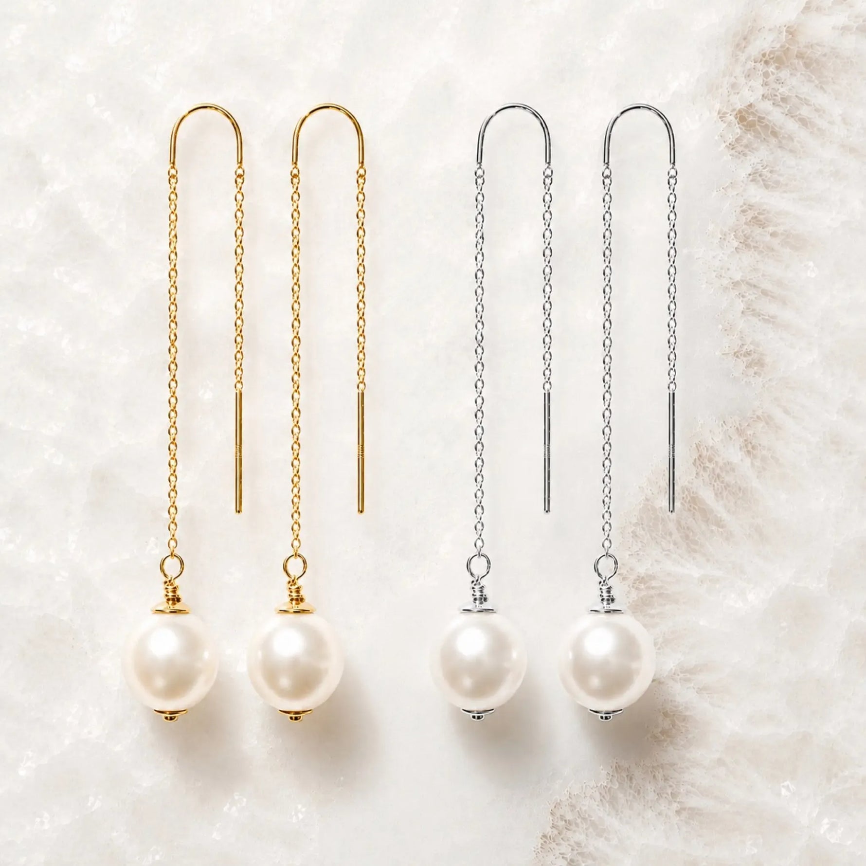 Gold and sterling silver threader pearl earrings displayed together for metal comparison on white quartz.
