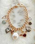 Close-up of Esme charm bracelet highlighting polished heart charms in mixed silver and gold tones.