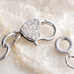 Close-up of the Esme Silver Charm Bracelet pavé heart clasp showing polished finish and handcrafted construction details.