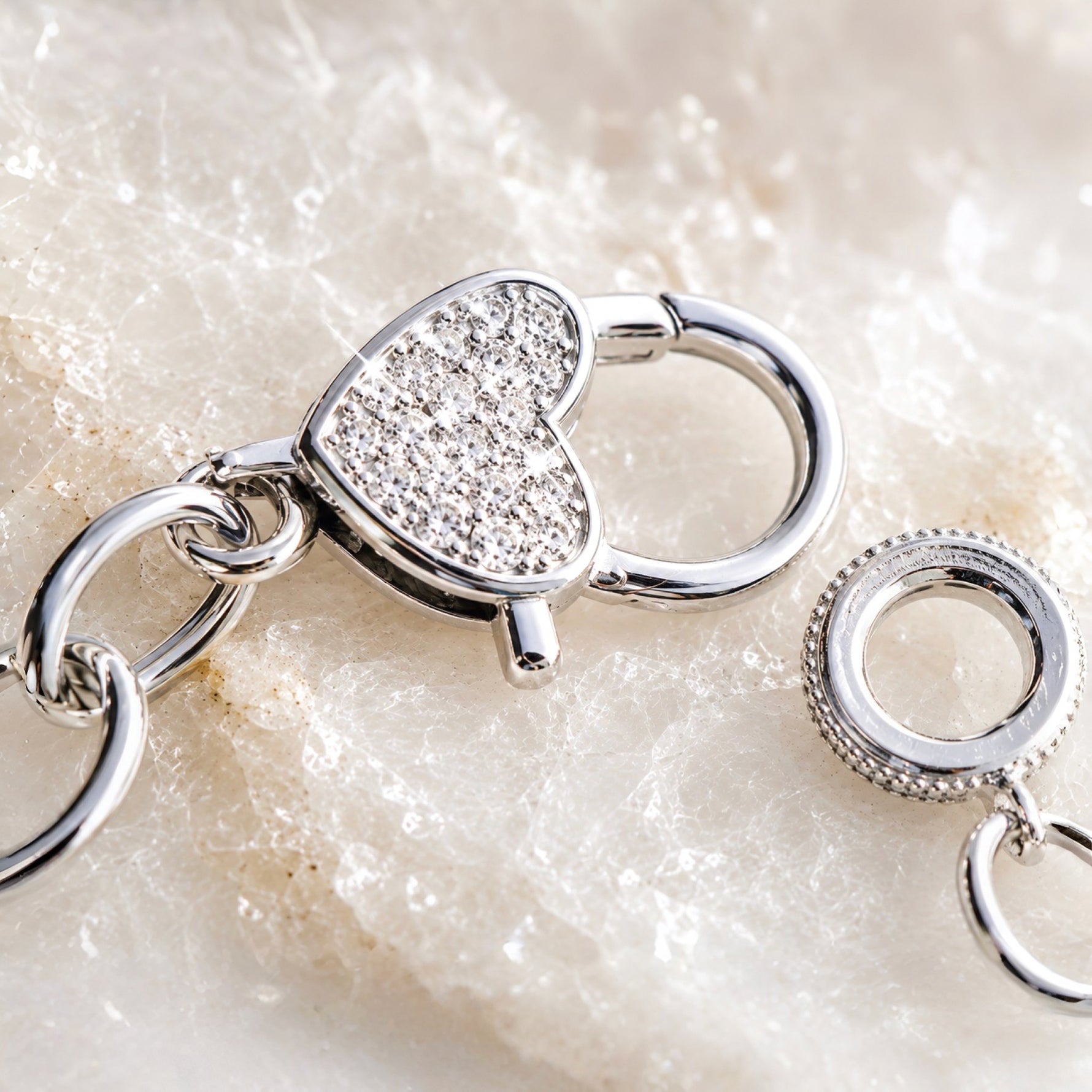 Close-up of the Esme Silver Charm Bracelet pavé heart clasp showing polished finish and handcrafted construction details.